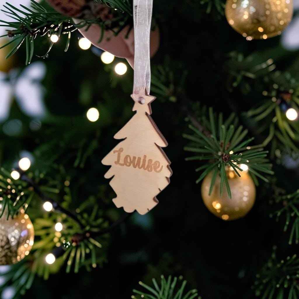 Décoration de Noël personnalisée en bois avec jusqu'à 7 prénoms. Petits sapins amovibles à accrocher dans le sapin familial. Une idée cadeau originale pour toute la famille.